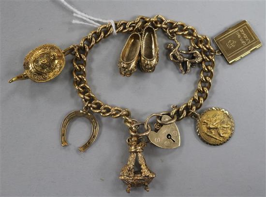 A 9ct gold charm bracelet, the curb-link chain with heart-shaped padlock clasp and hung with seven charms